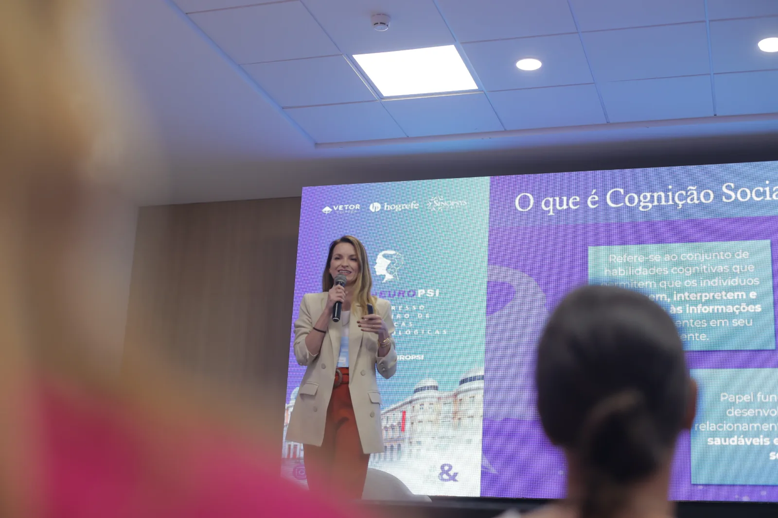 Bruna Trevisan apresentando bloco clínico em palco